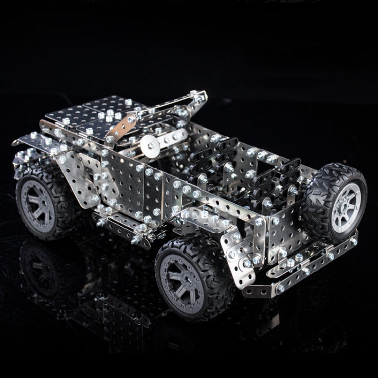 Metal off-road vehicle model toy with silver body panels and large black tires, rear 3/4 view