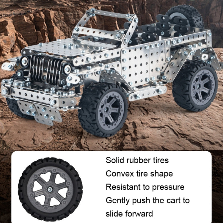 Metal off-road vehicle model toy with silver construction and black tread tires, outdoor angled view