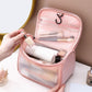 Pink frosted toiletry bag open, showing internal pockets and zip closure