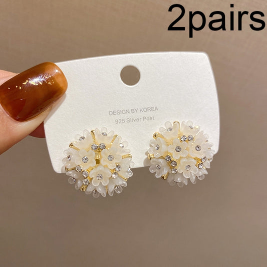 White crystal flower stud earrings with gold-tone posts, domed petal design.