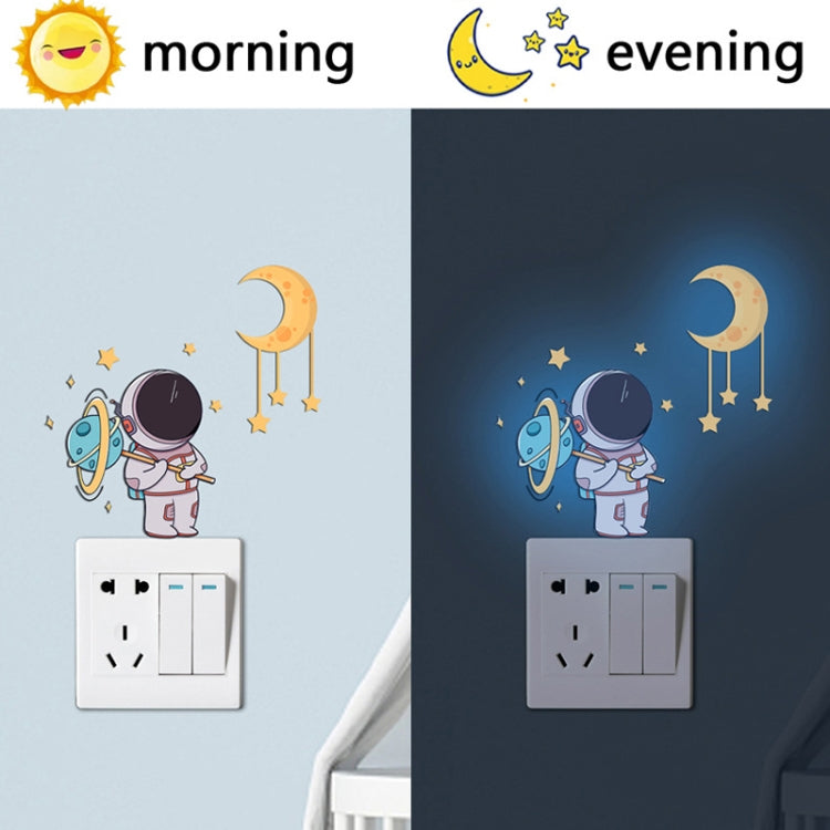 Astronaut, crescent moon, and star glow stickers on a light switch plate
