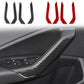 Black carbon-fiber style door armrest decorative stickers installed on car interior panel.