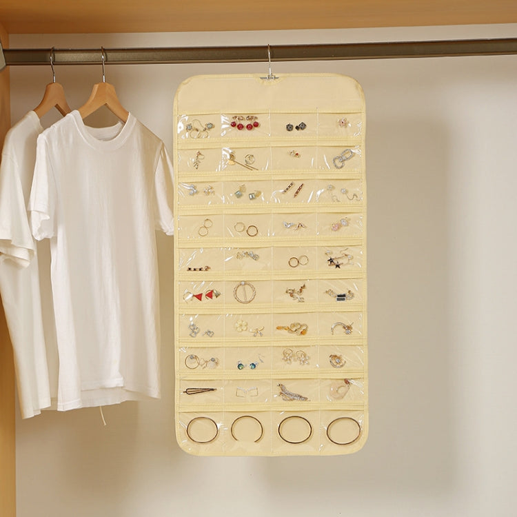 Light yellow hanging jewelry organizer bag with clear compartments and ring sections