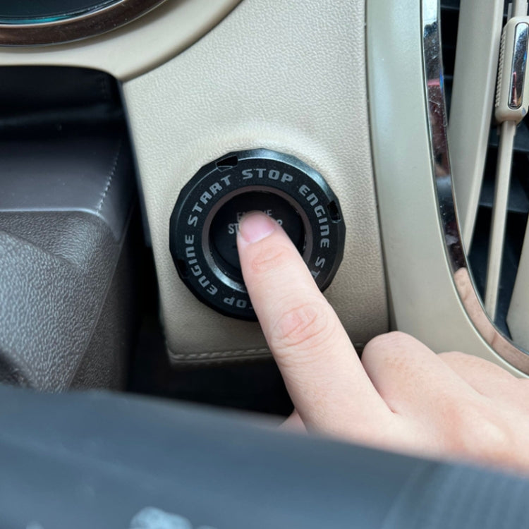 Black engine start/stop protective cover installed on car dashboard button