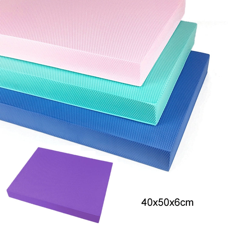 Stacked balance mats in teal, blue, and purple with textured non-slip surface.