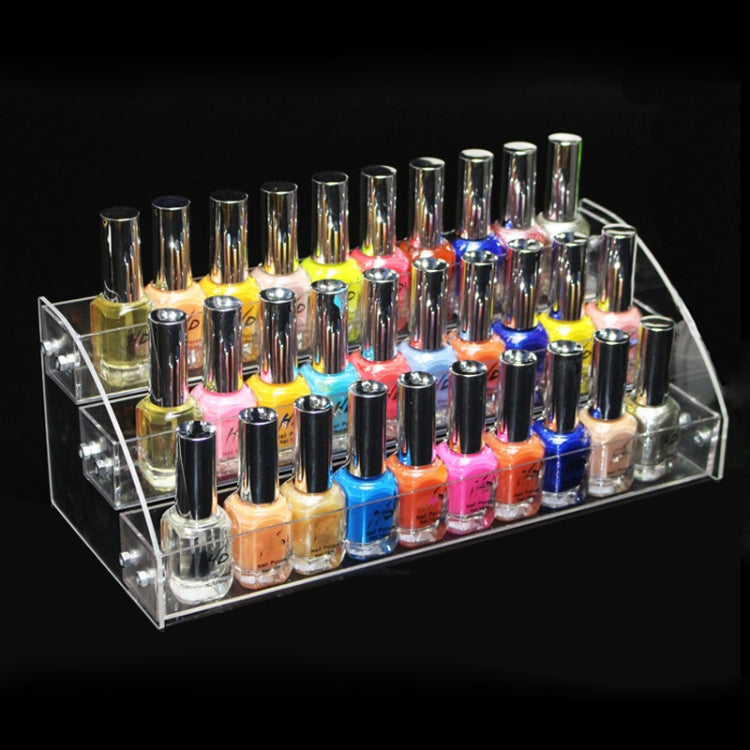 Transparent acrylic tiered nail polish display rack filled with colorful bottles