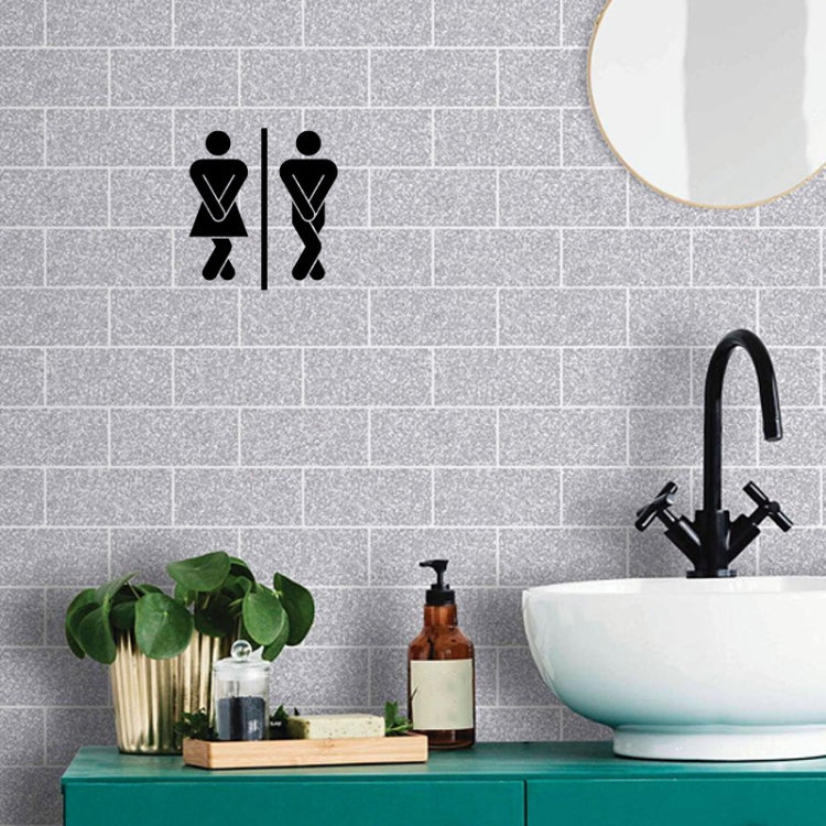 Bathroom door sticker with black restroom icons on gray tile wall