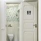 Bathroom door sticker with black restroom icons on white door panel