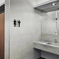 Bathroom door sticker with black restroom icons on light gray tiled wall
