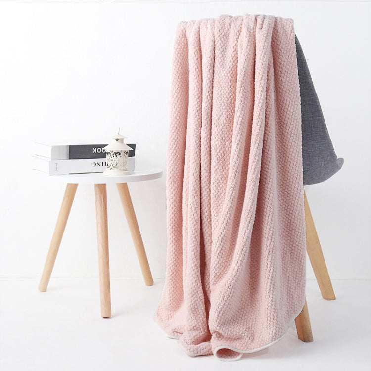 Light pink bath shower towel with waffle texture, draped over chair