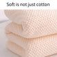 Light pink bath towel fabric close-up with raised waffle knit texture