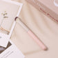 Angled concealer brush with rounded white head and pale pink handle