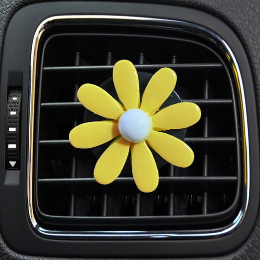 Yellow daisy air vent aromatherapy clip with light blue center, clipped to car vent