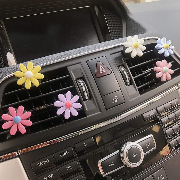 Colorful daisy car air vent clips along dashboard vents, five-petal flowers