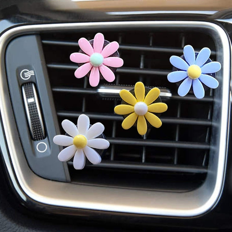 Multiple daisy air vent aromatherapy clips in pink, blue, yellow, and white on car vent