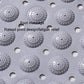 Gray PVC bathroom mat surface with raised round massage nodes and drainage holes