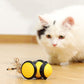 Yellow and black motorized cat teasing toy moving on floor with feather toy visible