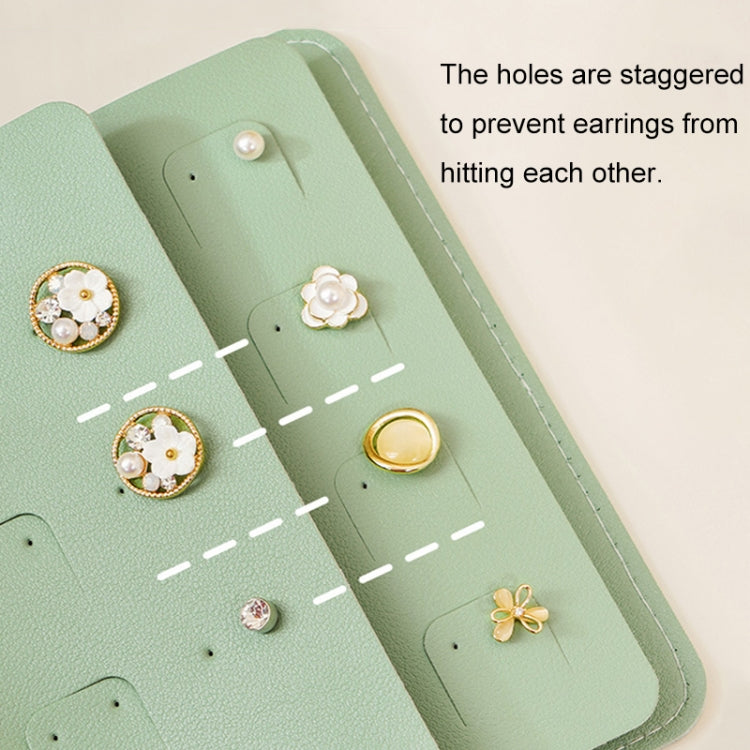 Inside view of green jewelry bag showing earring holes and separate storage sections