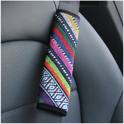 Car seat belt shoulder pad with colorful woven stripes on gray car seat