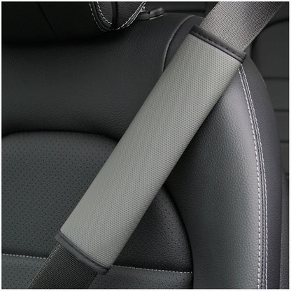 Gray car seat belt shoulder pad cover with textured surface and stitched edges
