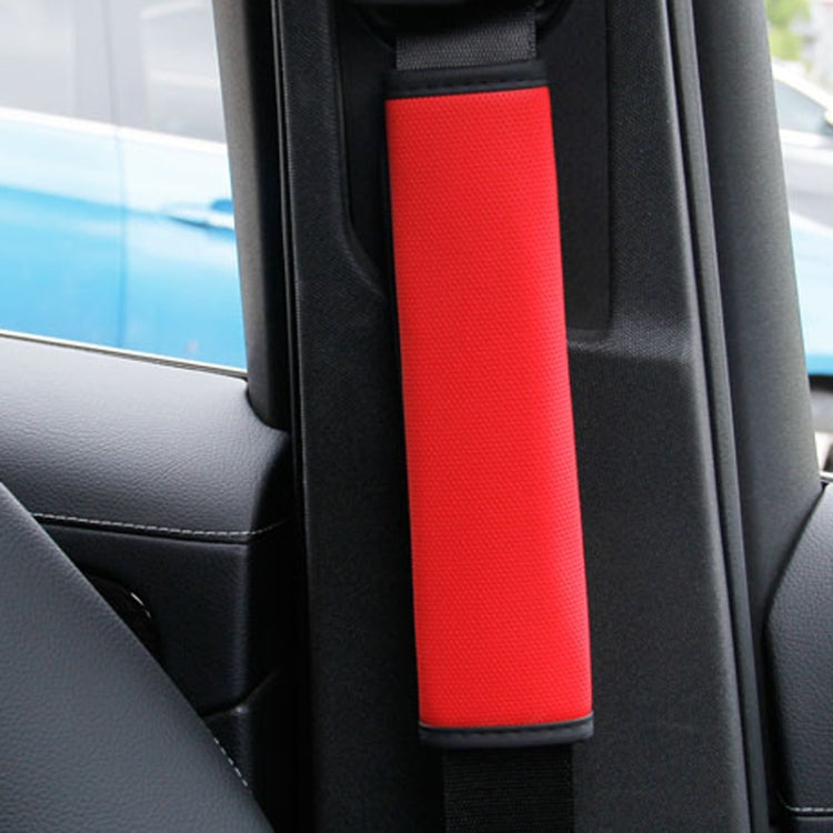 Red and black seat belt shoulder pad cover installed on a car seatbelt