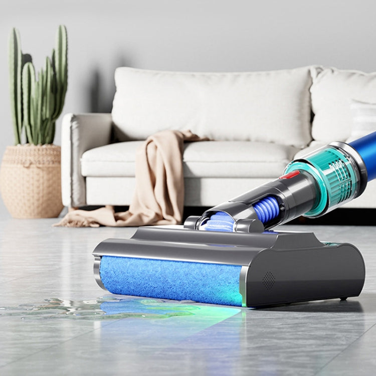 Wet vacuum mopping head with blue roller on hardwood floor with a small water puddle.