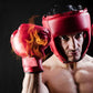 Red boxing sparring helmet with black face cage worn by an athlete