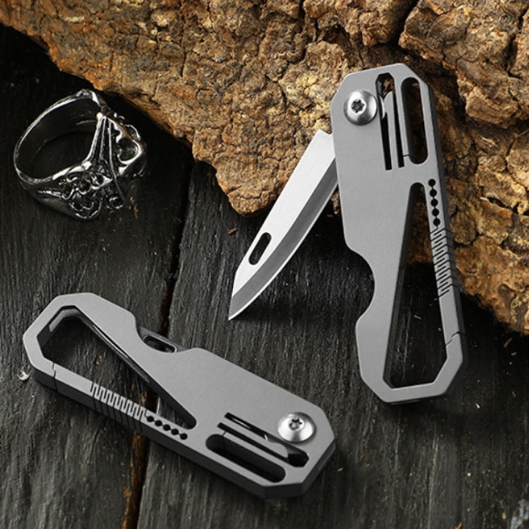 Folding mini titanium defense knife with blade open and two keychain rings