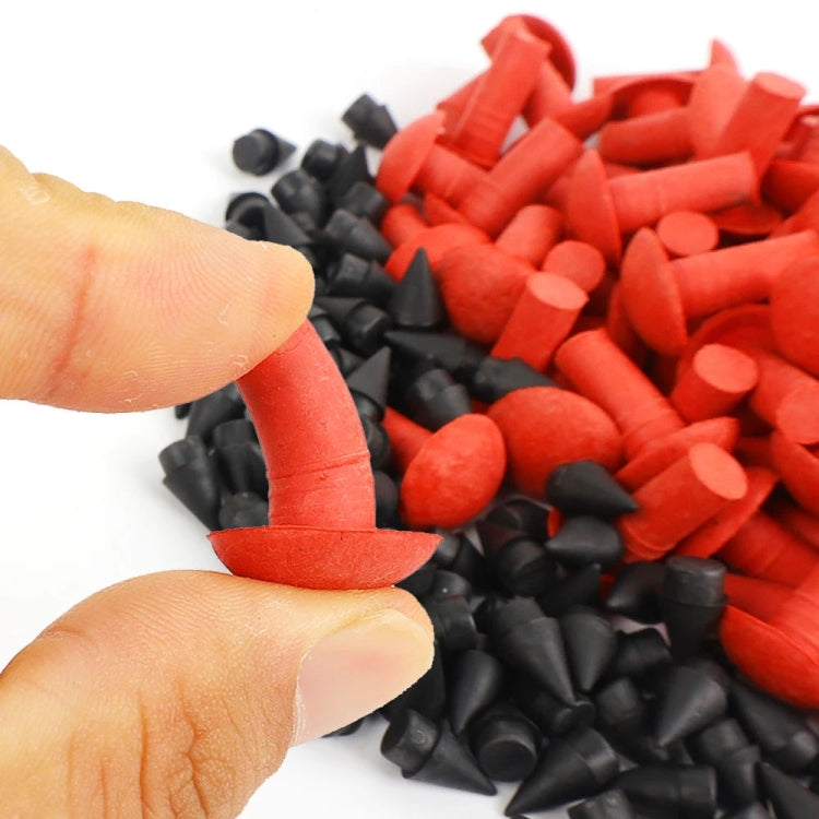 Hand holding a red tire repair mushroom plug among red and black plug pieces