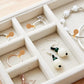 Tan jewelry tag sticker icons placed on jewelry organizer compartments
