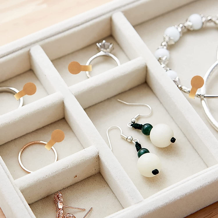 Tan jewelry tag sticker icons placed on jewelry organizer compartments