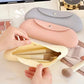 Pink silicone makeup brush storage bag open, holding makeup brushes and tools