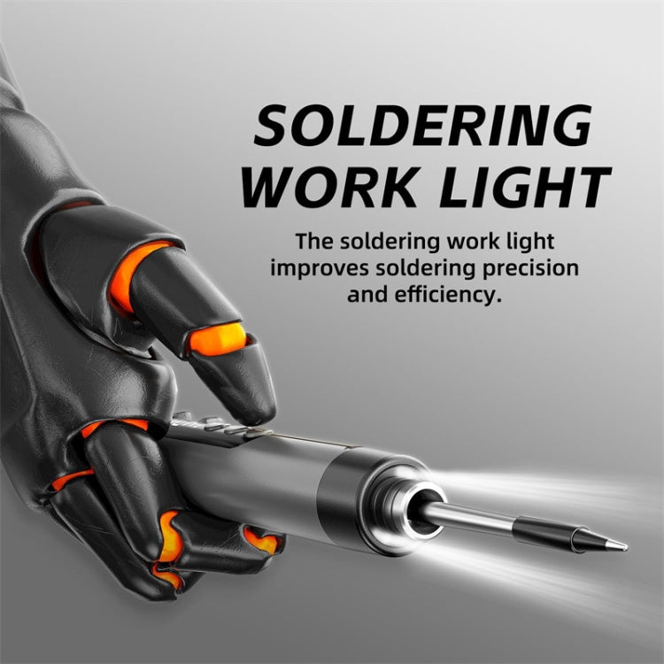 Soldering iron with orange button, shown in black-gloved hands for precise work
