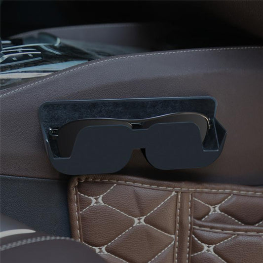 Adhesive car glasses case in black, mounted on a car dashboard