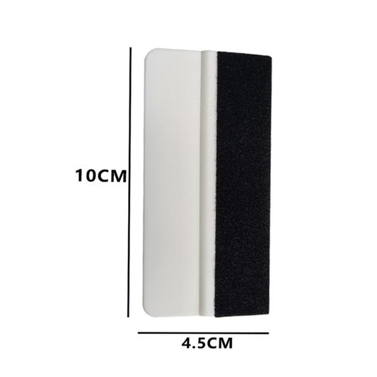 Two-sided felt scraper pad, white and black, approx 10 cm by 4.5 cm
