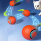 Orange self-rolling cat toy ball with green tentacle, motion arcs, and black base.