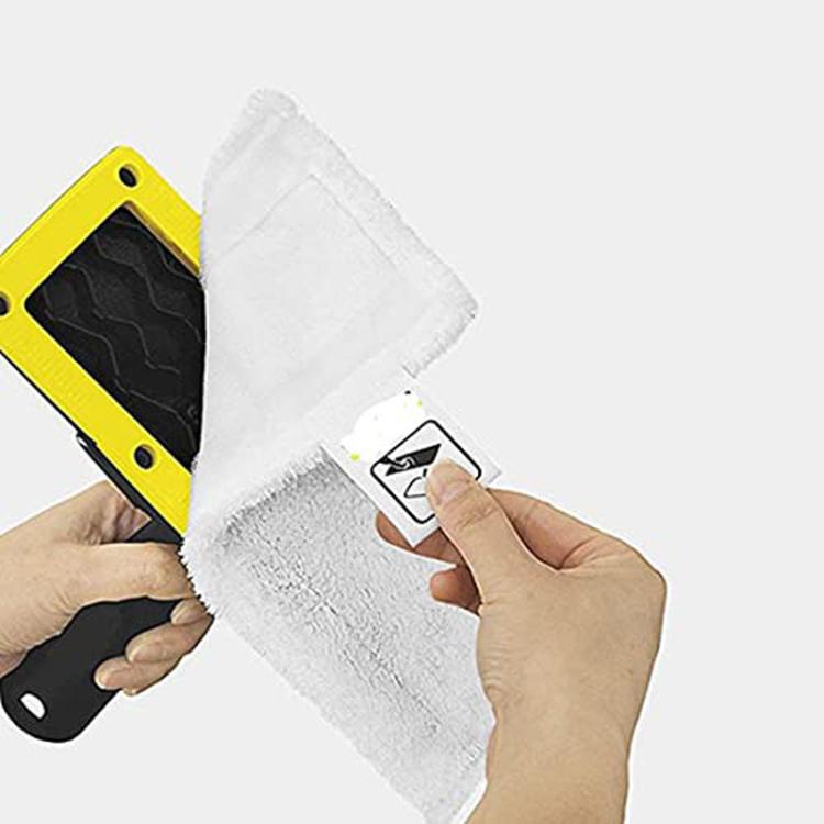 Steam floor brush with removable cloth pad attachment held in hands
