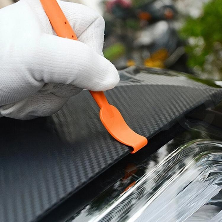 Gloved hand using an orange edge squeegee scraper to apply car film