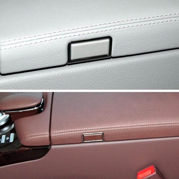 Installed car center armrest switch on leather panel, rectangular dark bezel
