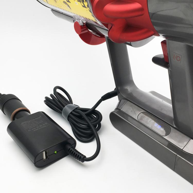 Car vacuum charger adapter and cable placed near vacuum base