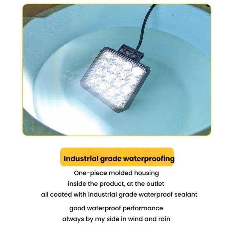 Square LED work headlight casting a bright white light beam