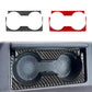 Two-piece gear shift cup holder trim, carbon-fiber black and red, with circular cutouts