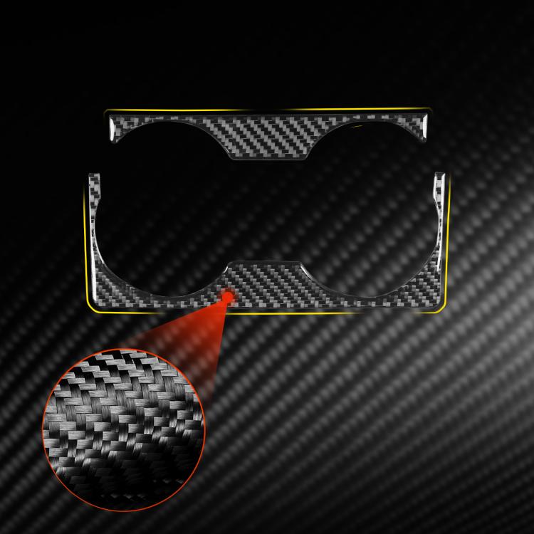 Black carbon-fiber gear shift cup holder trim with two circular openings, close-up