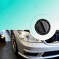 Headlight dust cover on Mercedes-Benz headlamp area, black round protective cap