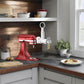 KitchenAid pasta maker attachment mounted on stand mixer with feed tube and handle