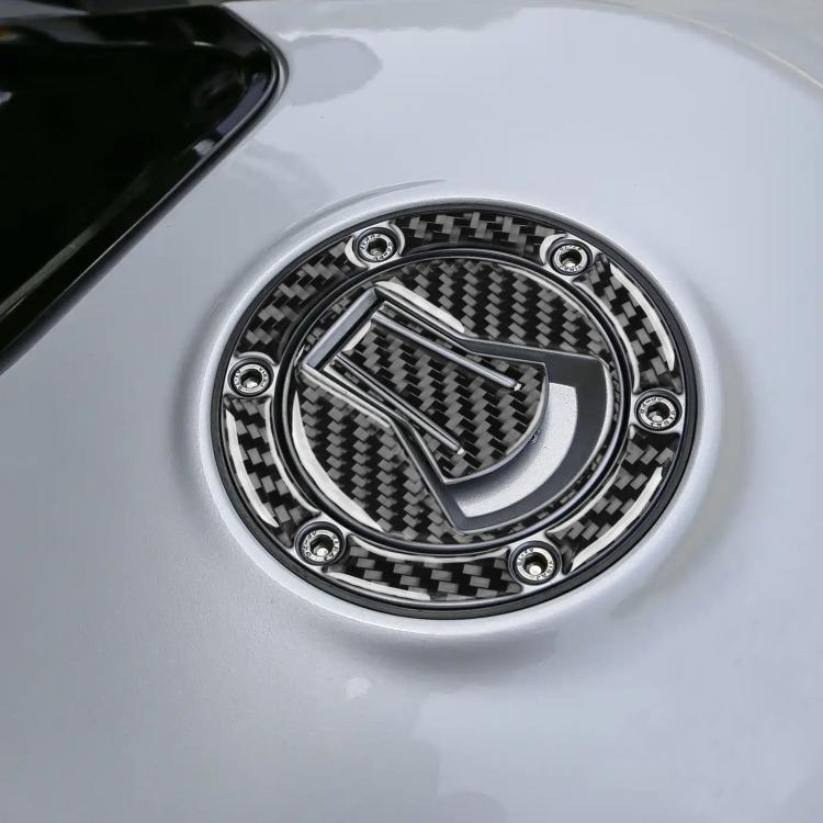 Black carbon-fiber fuel tank cap sticker with circular metal-style ring and bolt accents