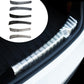 Stainless steel trunk sill guard on car sill with silver ribbed sections and black base
