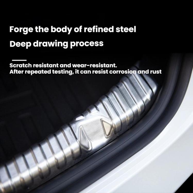 Stainless steel trunk sill guard with silver ribbed finish along the car trunk edge