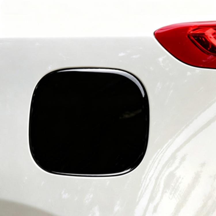 Glossy black fuel door sticker on white vehicle body panel