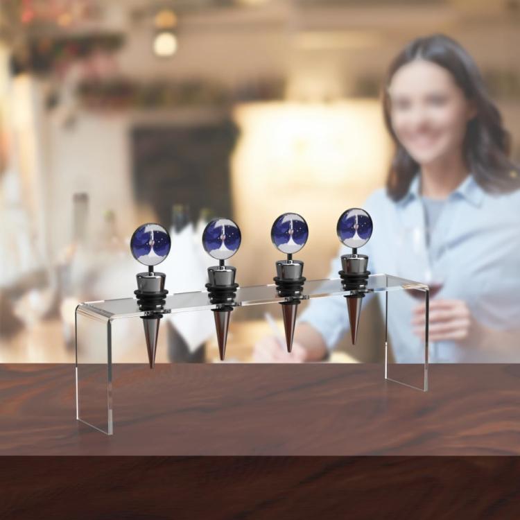 Clear acrylic wine stopper display stand with four blue-top stoppers on table